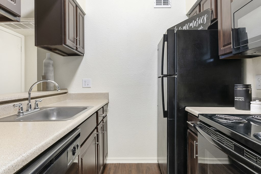 A kitchen with a black fridge and stove.