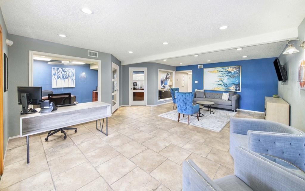 A living room with a grey couch and a blue chair.