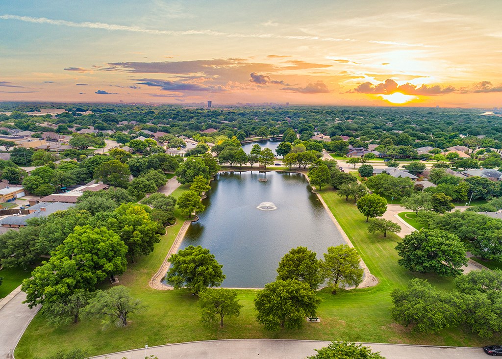 an aerial view of a lake in a park at sunset