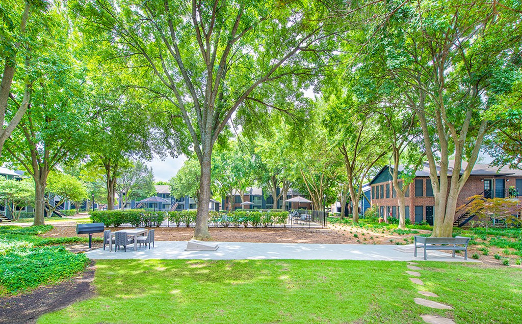 a park with benches and trees in front of a building
