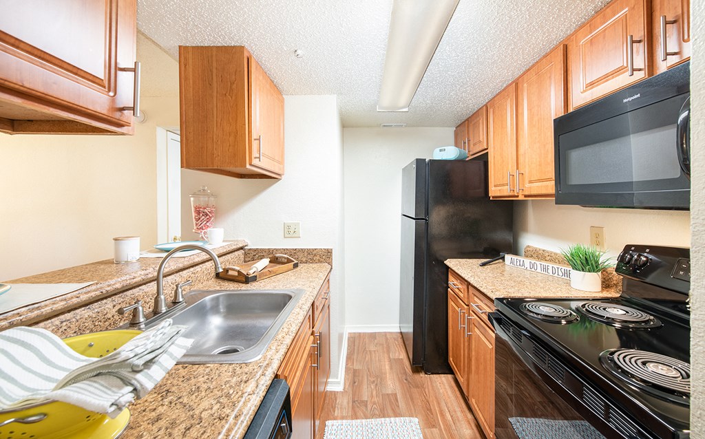 a kitchen with black appliances and granite counter tops