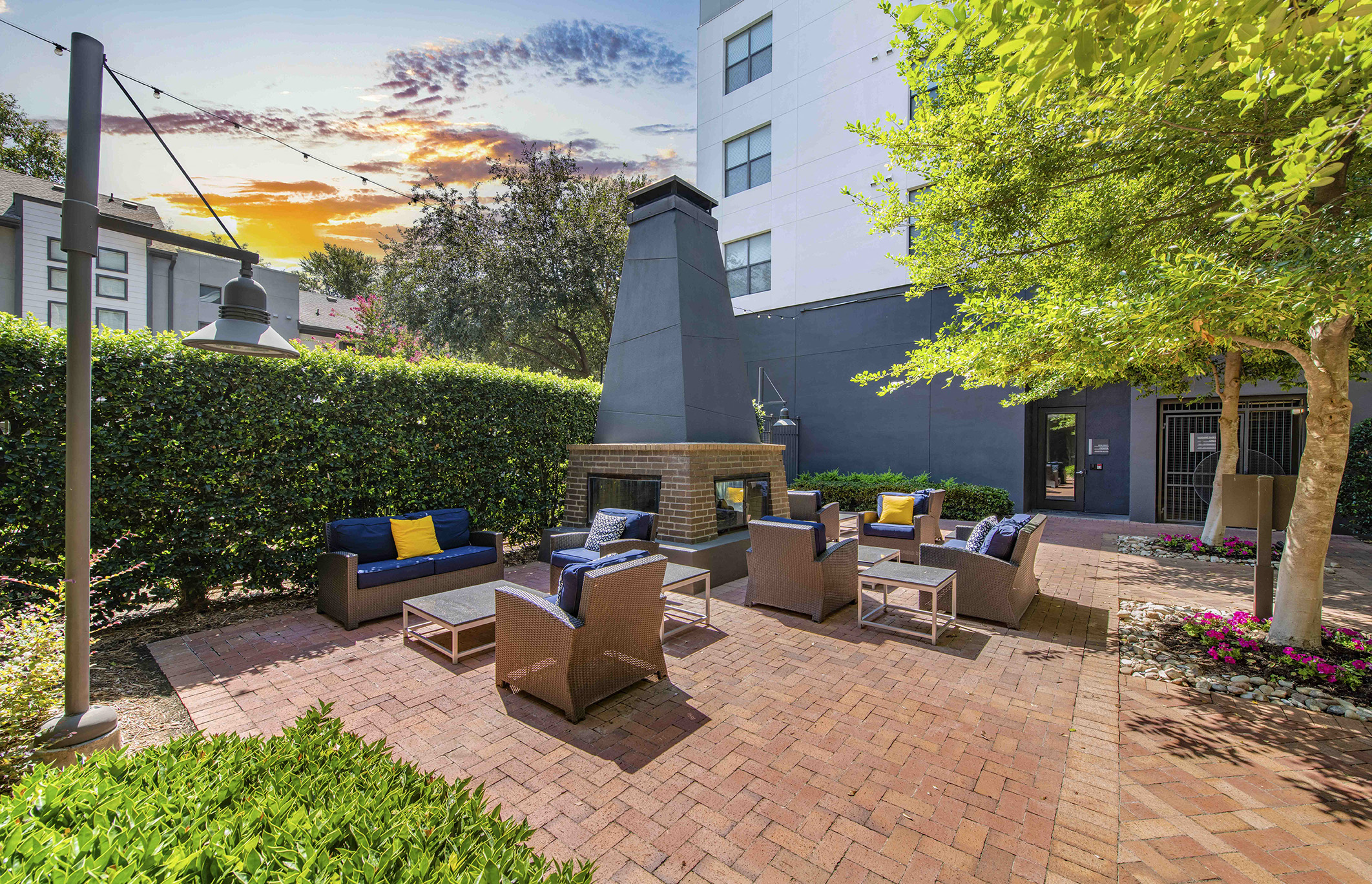 a patio with chairs and a fireplace in front of a building
