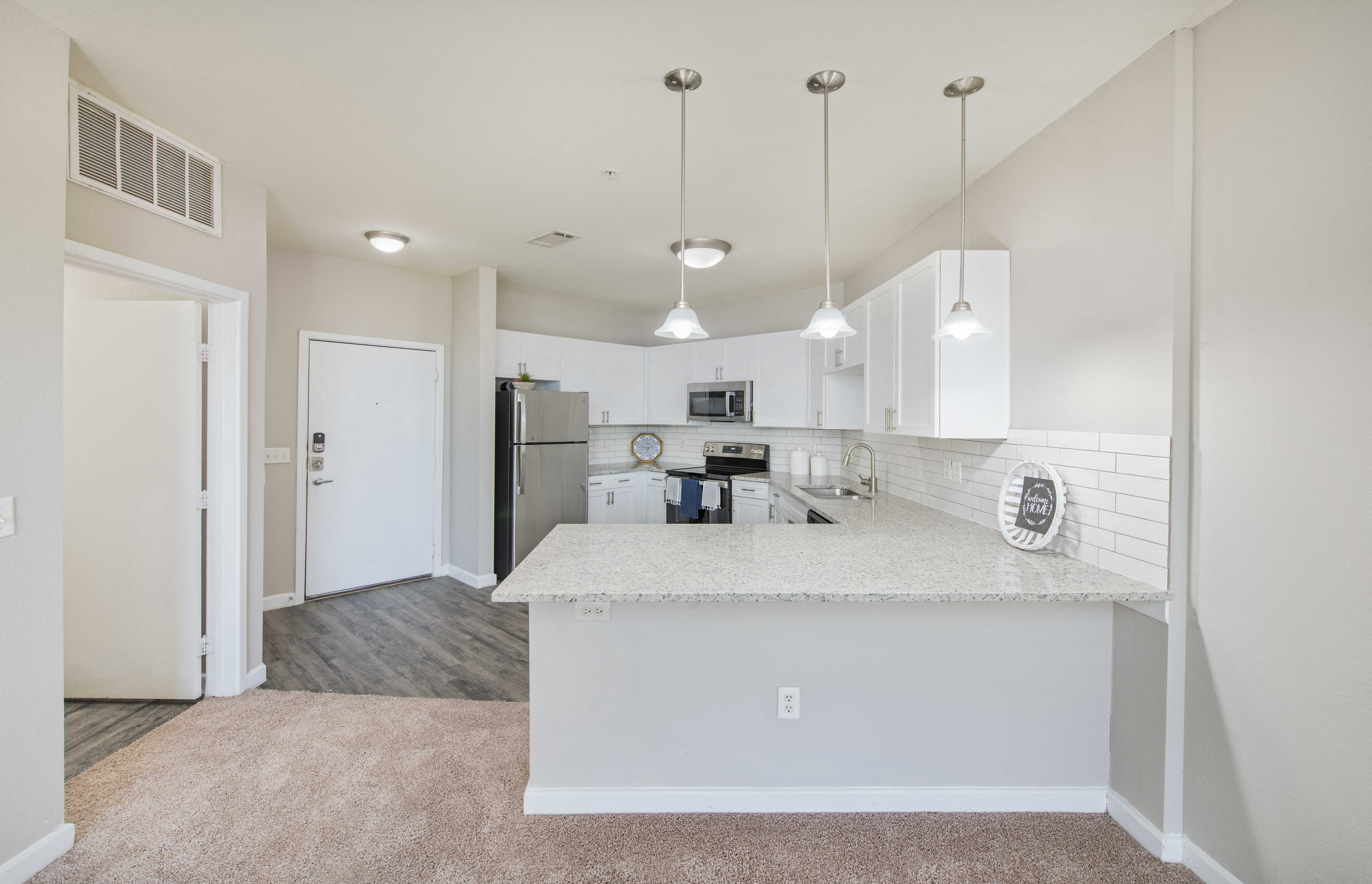 a spacious kitchen with white cabinets and a white counter top