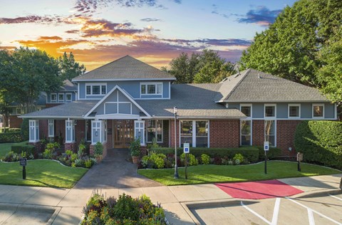 a large house with a sunset in the background
