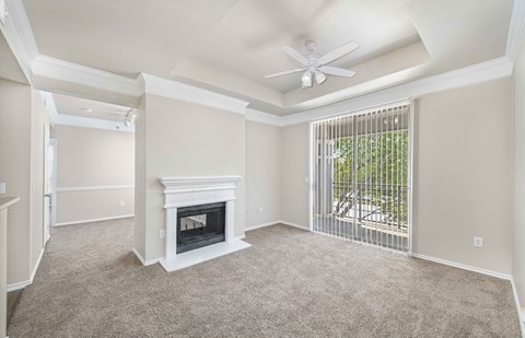 a living room with a fireplace and a ceiling fan