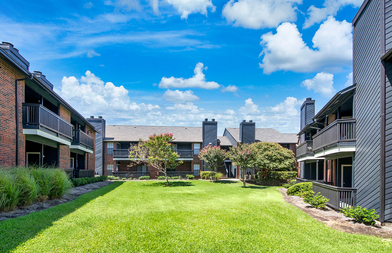 a grassy yard between two apartment buildings