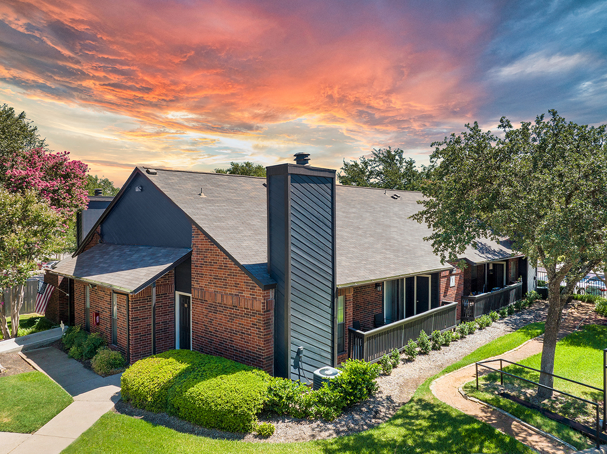 the view of a house with a colorful sky above it