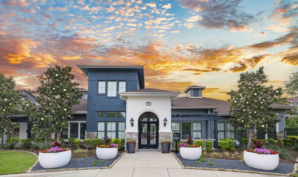 the front of a house with a sunset in the background