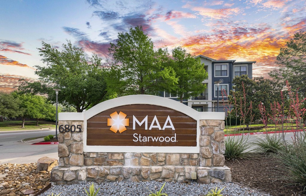 a stone monument with a sign that says on it with trees
