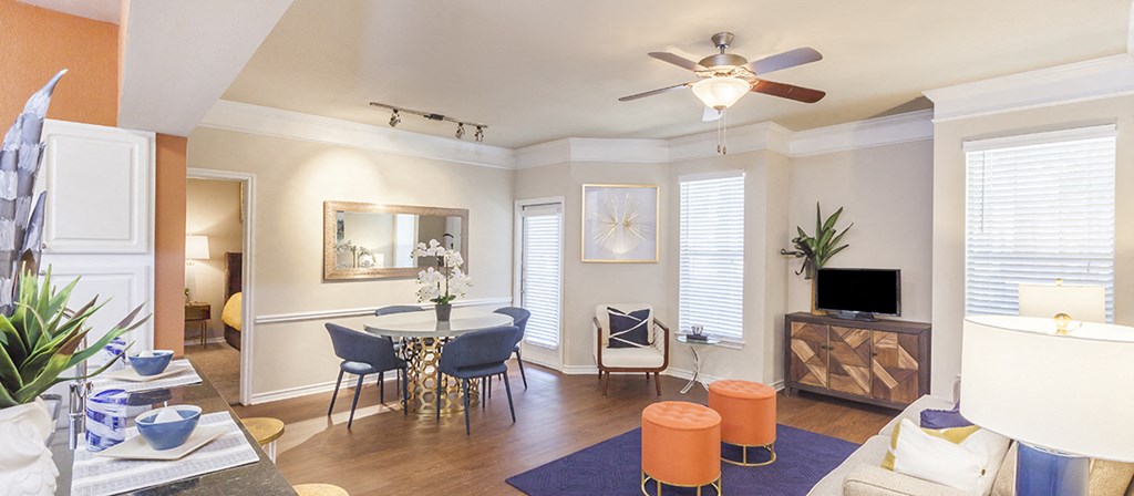 a living room with a dining room table and a ceiling fan