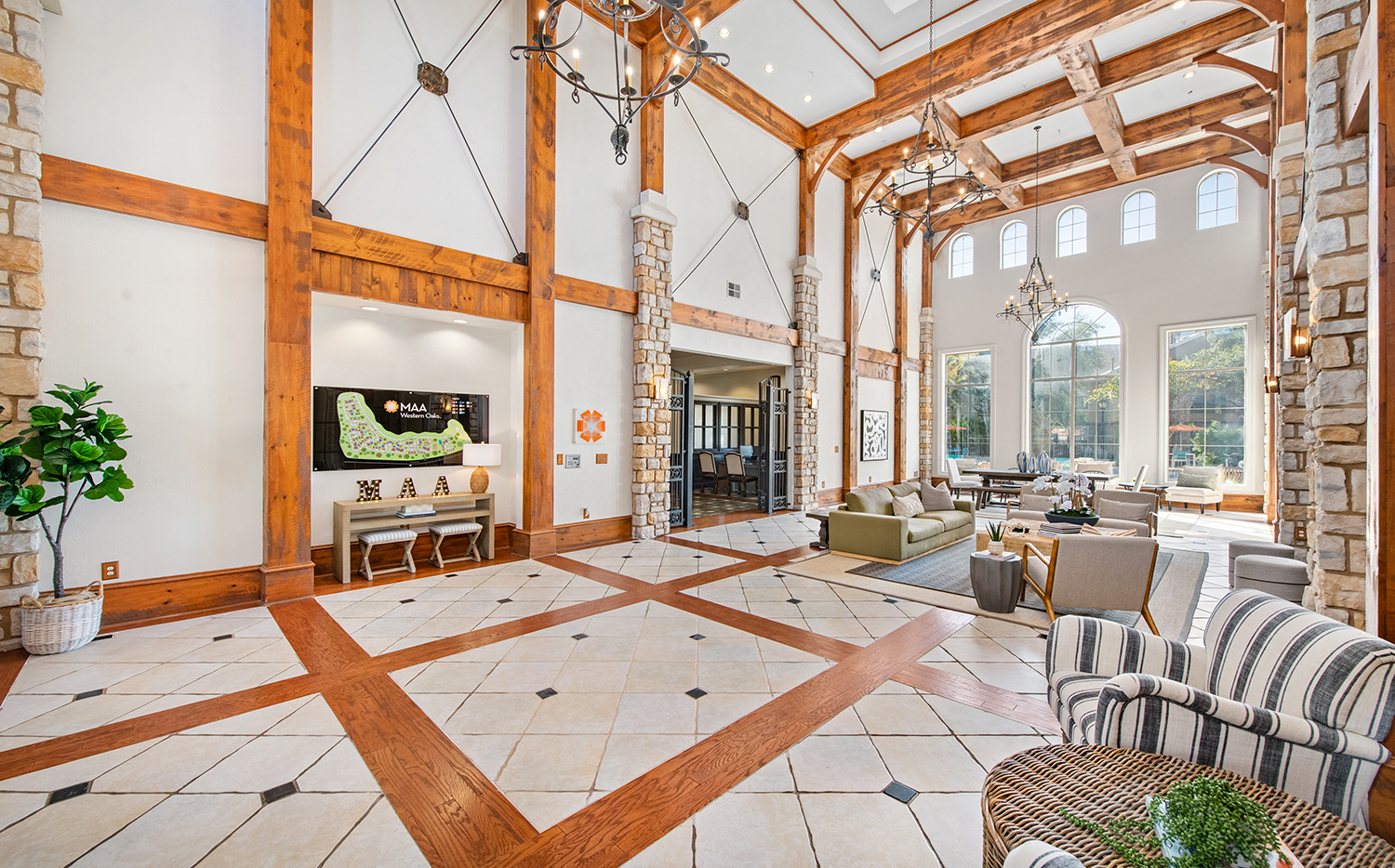 a large living room with wooden beams and tile floors and a fireplace