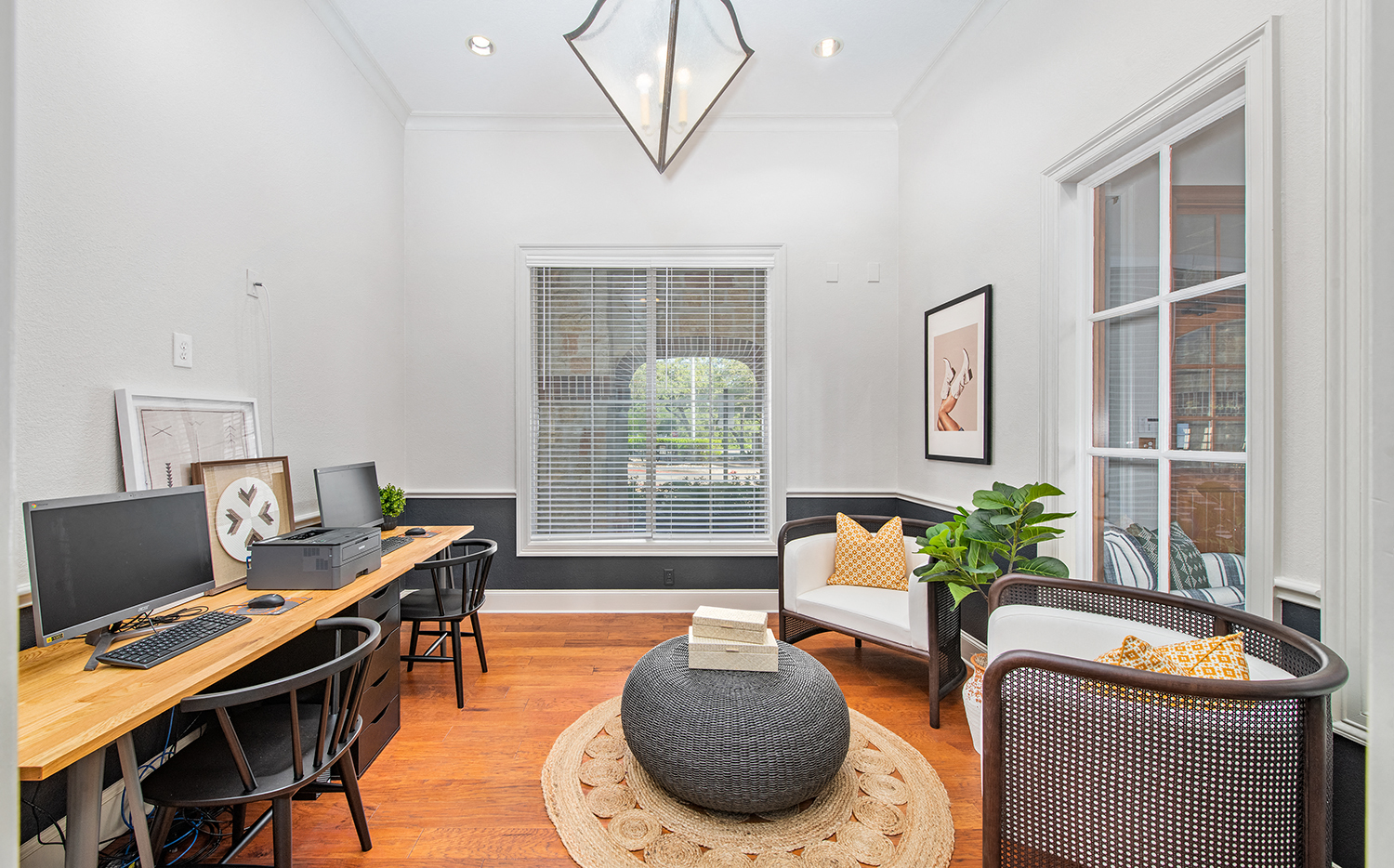 a living room with a desk with a computer and a window