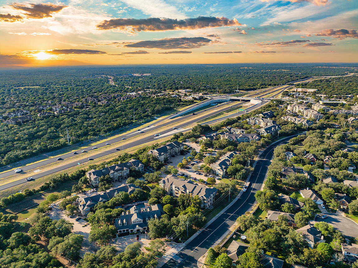 an aerial view of a city with highways and houses