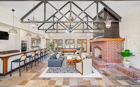a large living room with a brick fireplace and a table with chairs