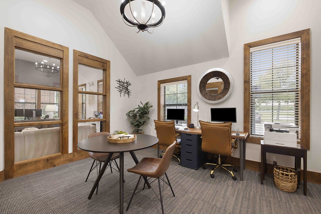 A room with a desk, chairs, and a computer.