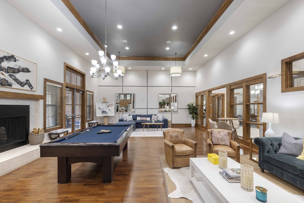A large, well-lit room with a pool table and comfortable seating.