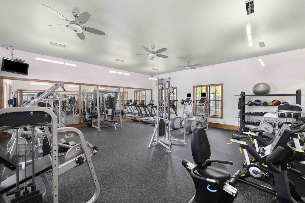 A spacious gym with a variety of equipment including treadmills, weights, and exercise machines.