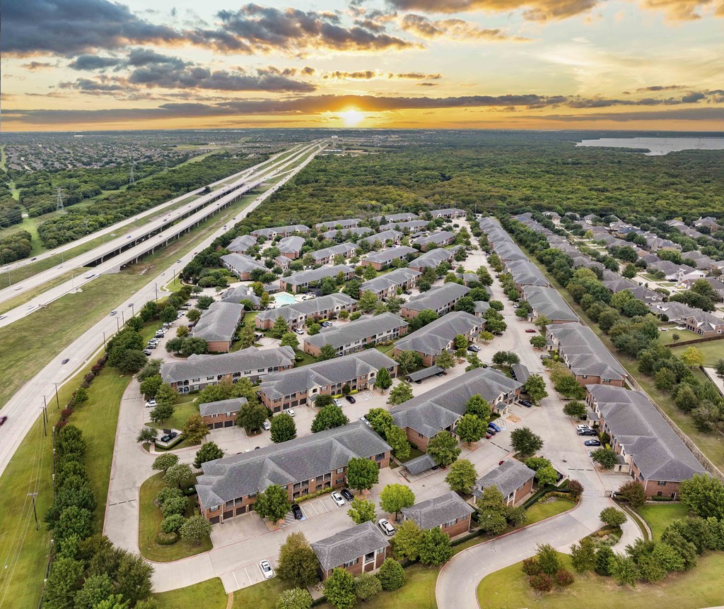 A sunset view of a residential area with houses and a highway.