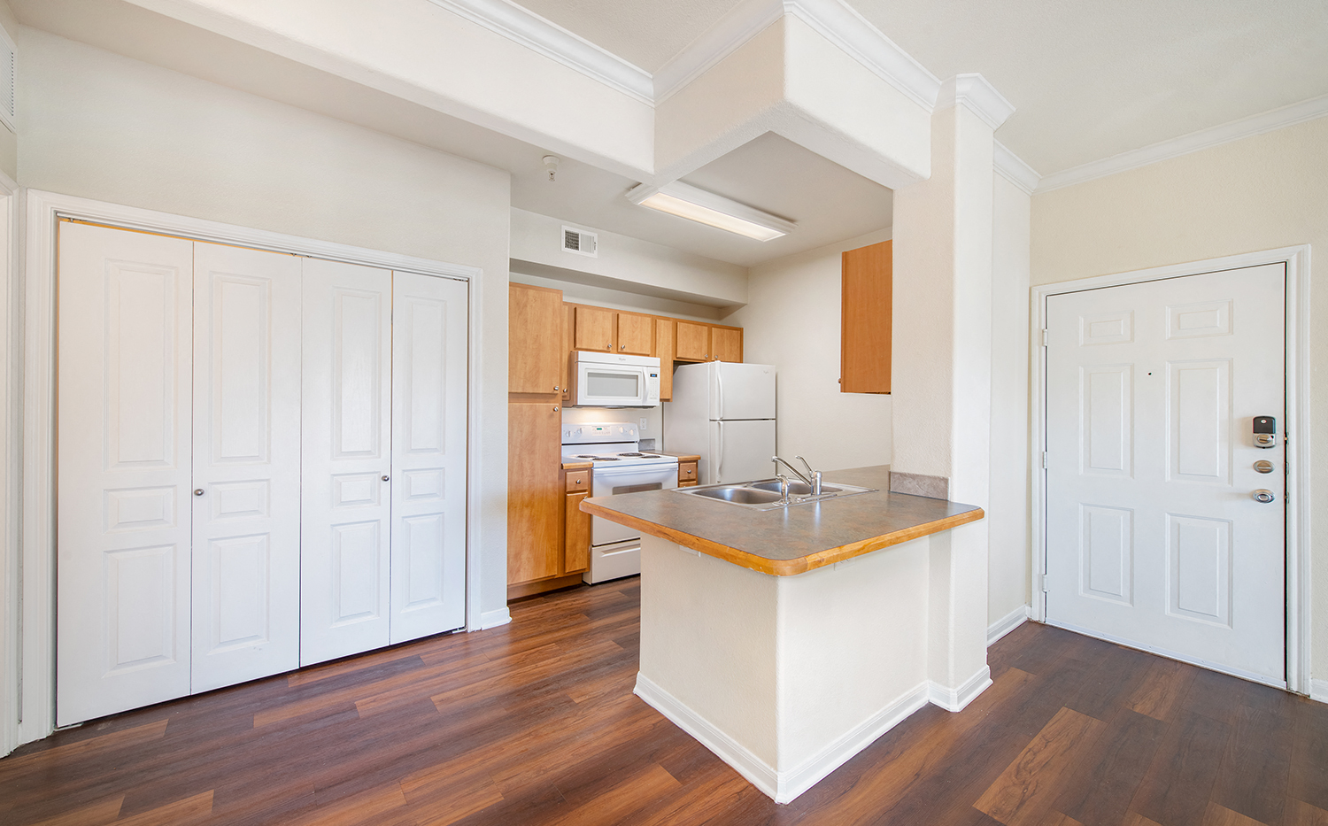 an empty kitchen with white doors and a counter top