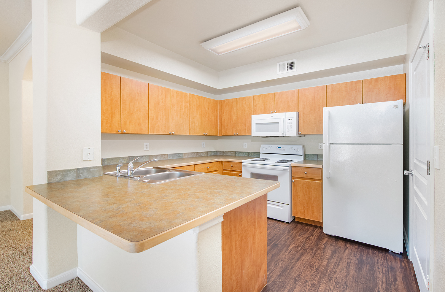 a kitchen with white appliances and wooden cabinets