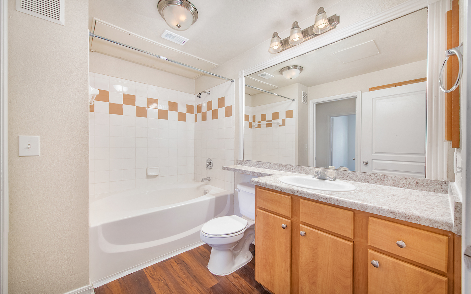 a bathroom with a tub sink and toilet and a mirror