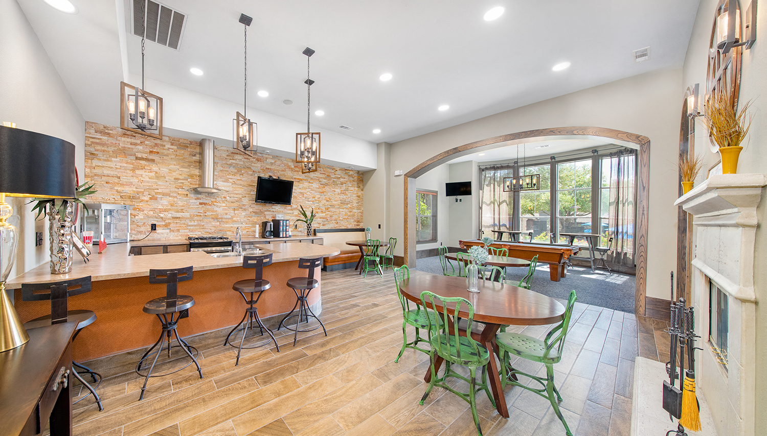 a clubhouse with a bar and a dining area with tables and chairs