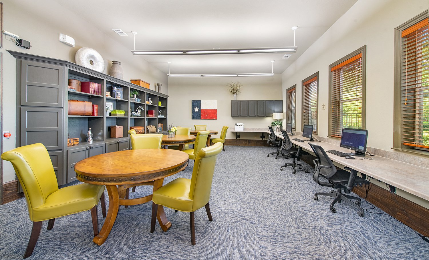 a room with tables and chairs and a computer