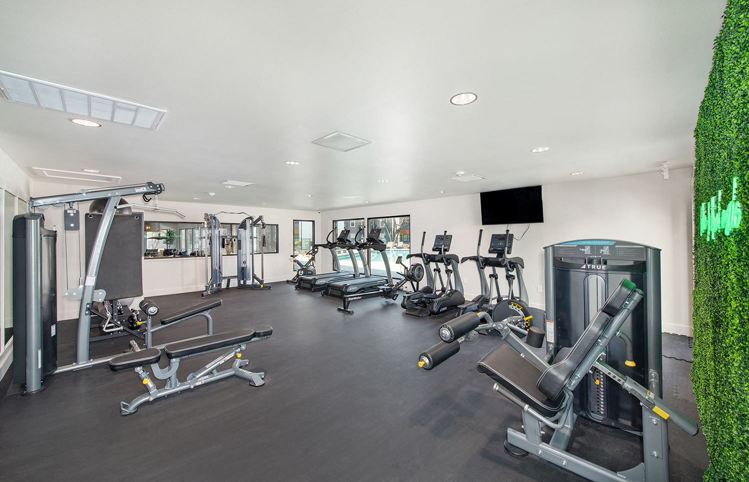 a gym with various exercise equipment and a television