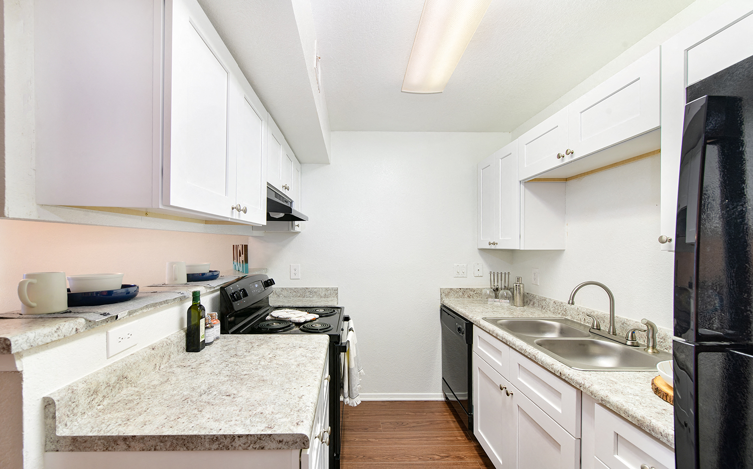 a renovated kitchen with granite counter tops and white cabinets