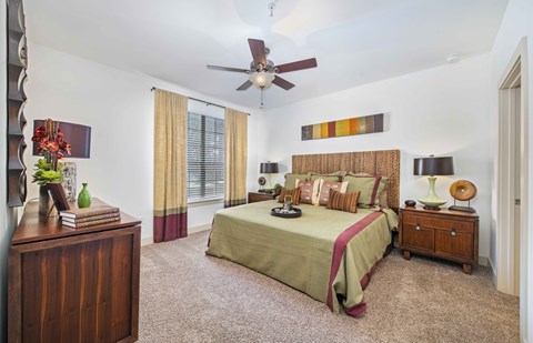 a bedroom with a large bed and a ceiling fan