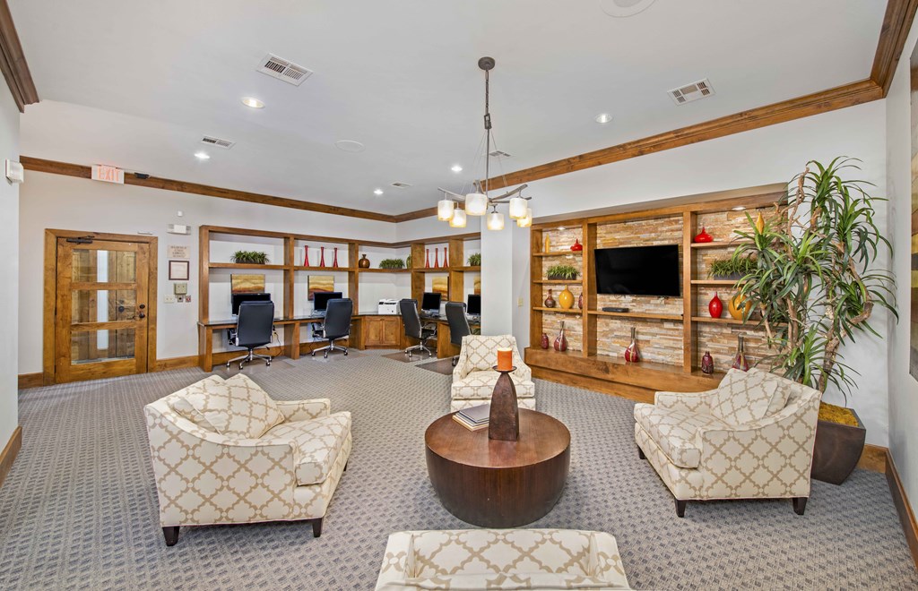 a lobby with chairs and a table and a television