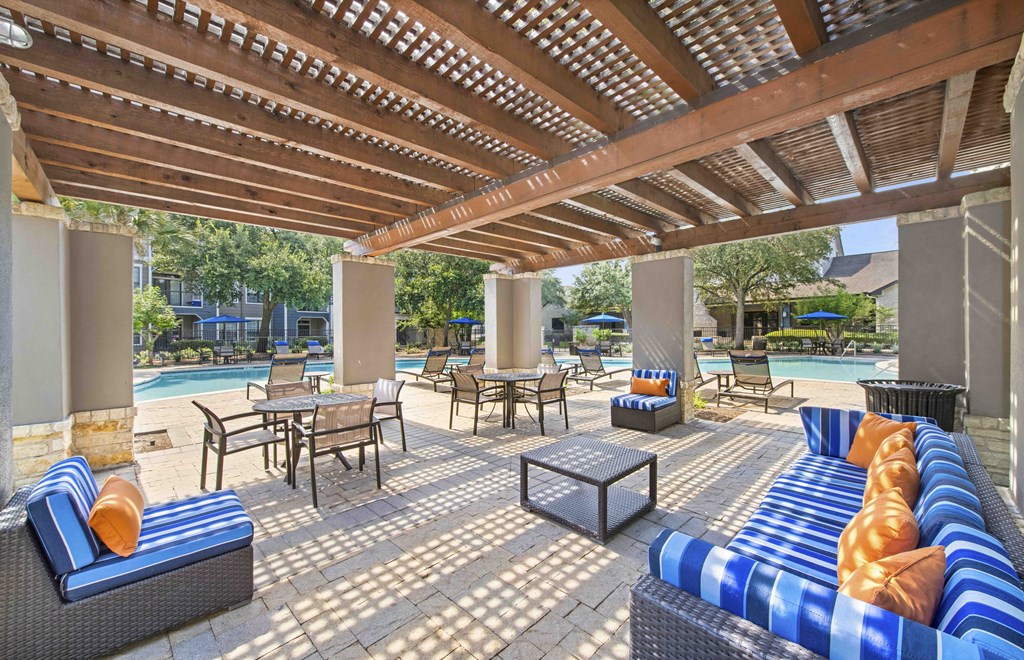 a covered patio with couches and tables