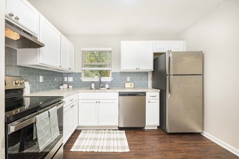 A kitchen with a black stove top oven and a black refrigerator.
