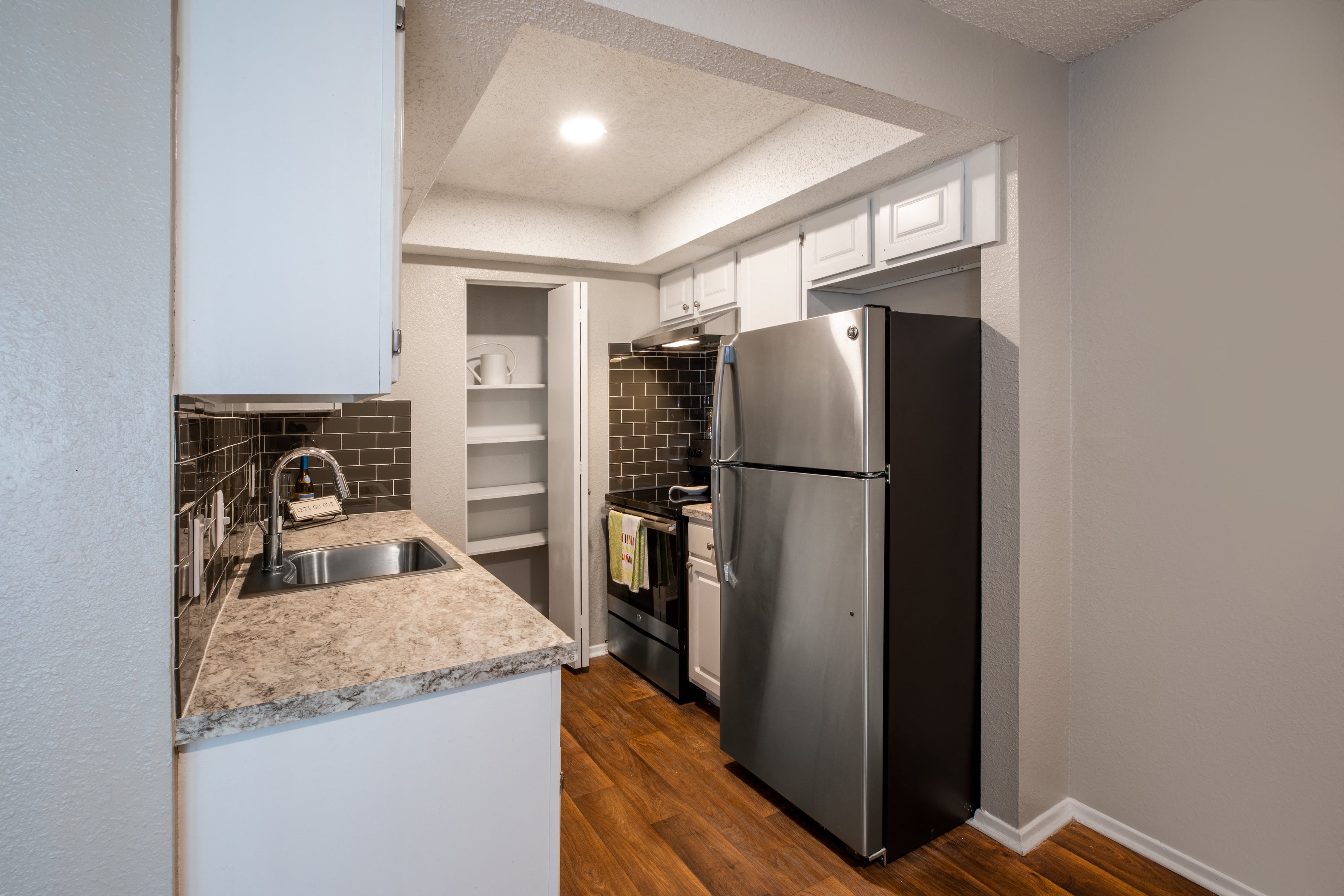 a kitchen with a stainless steel refrigerator and a sink