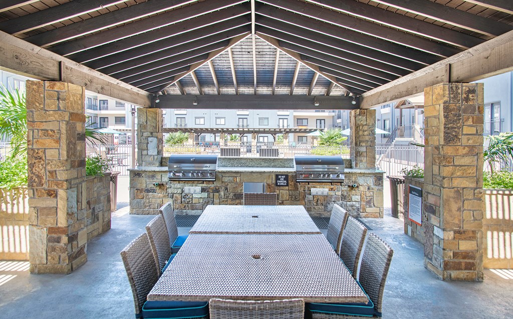 a large patio with a dining table and a bar