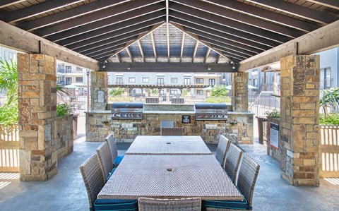 a large patio with a dining table and a bar