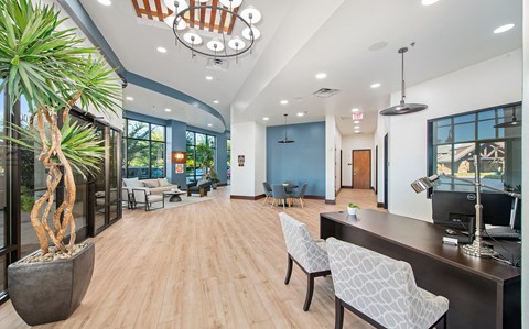 the lobby of a building with a reception desk and chairs