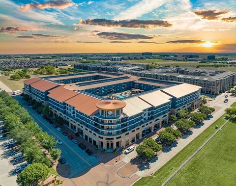 an aerial view of a building with a sunset in the background