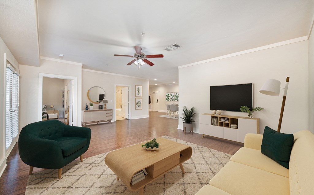 a living room with white walls and a ceiling fan