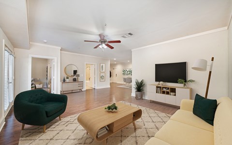 a living room with white walls and a ceiling fan