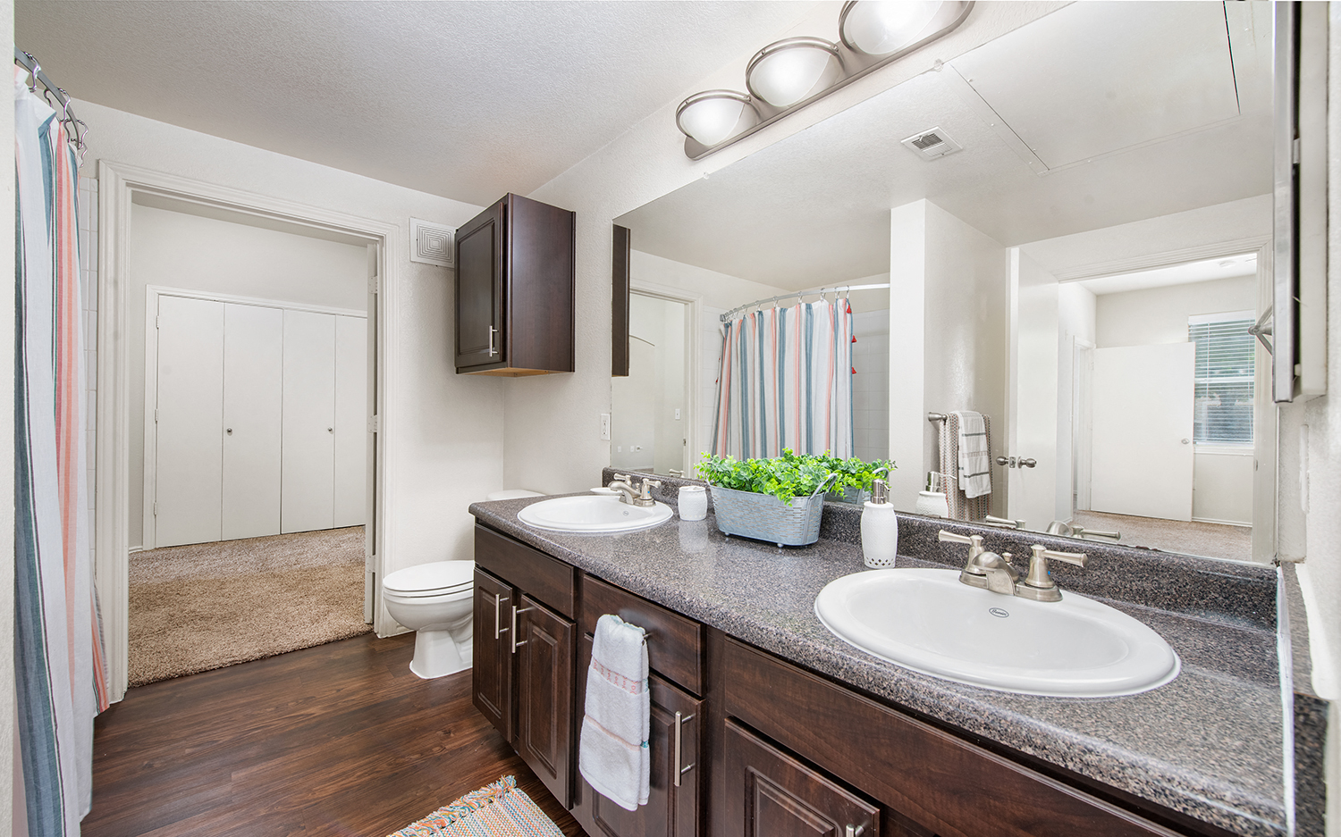 a bathroom with two sinks and a toilet and a mirror