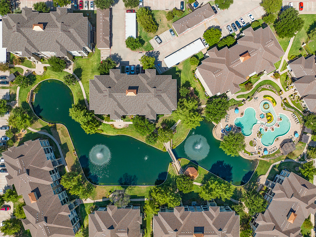 a birdseye view of a neighborhood with a swimming pool and a private pond