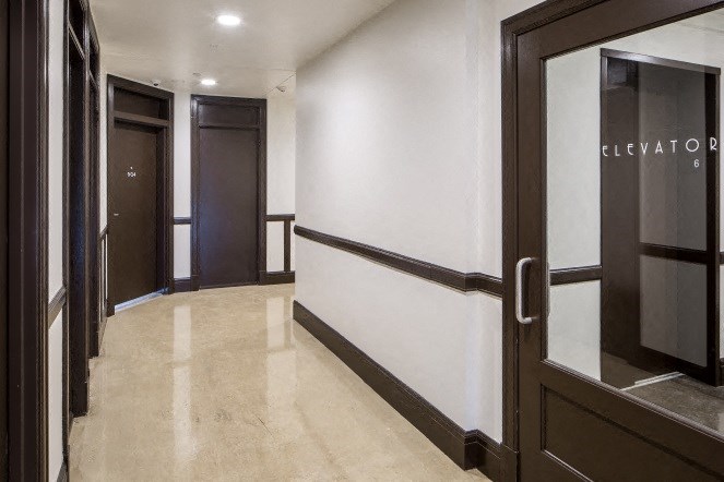the lobby of a building with doors and a white wall