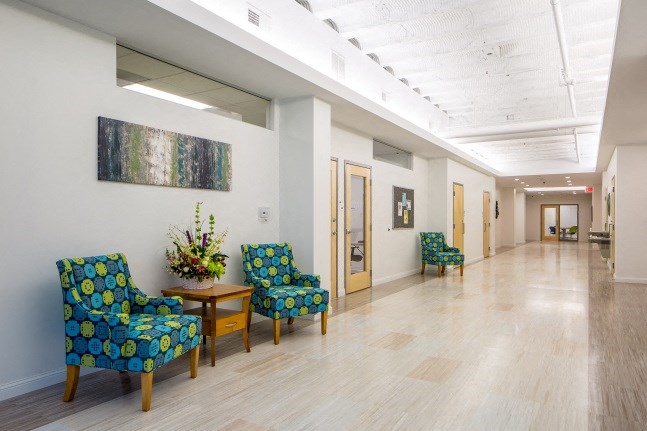 the lobby of a building with chairs and a table