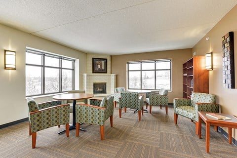 a living room with chairs and tables and a fireplace