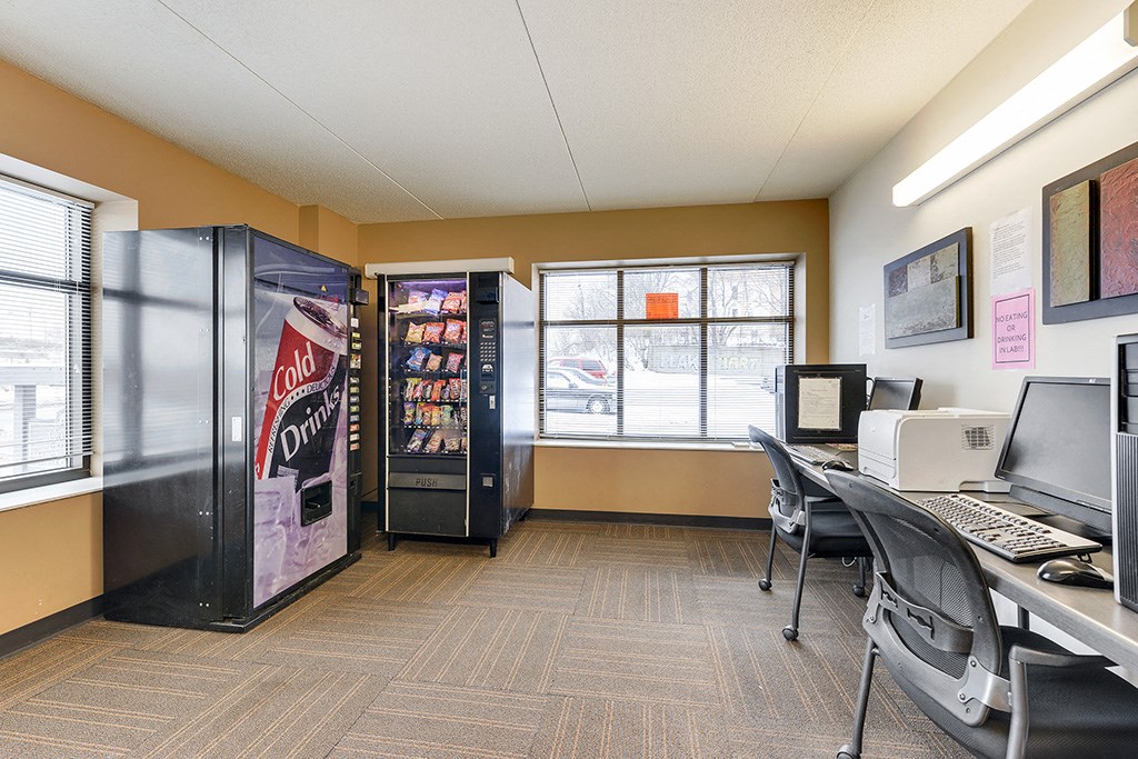 a break room with a computer and a vending machine