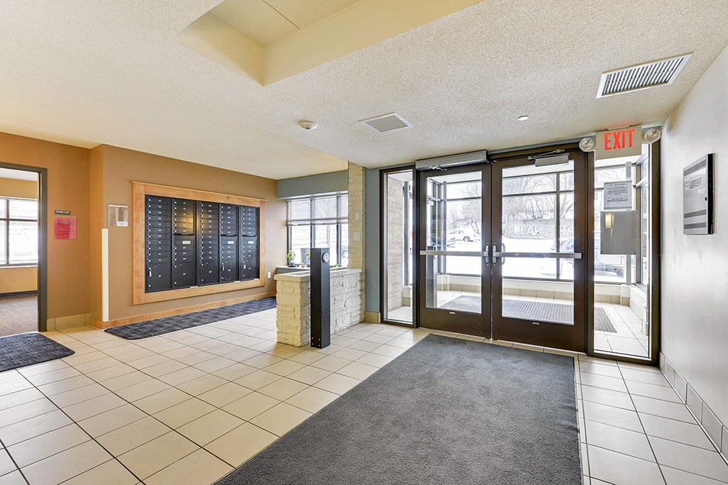 the lobby of a building with glass doors and a rug