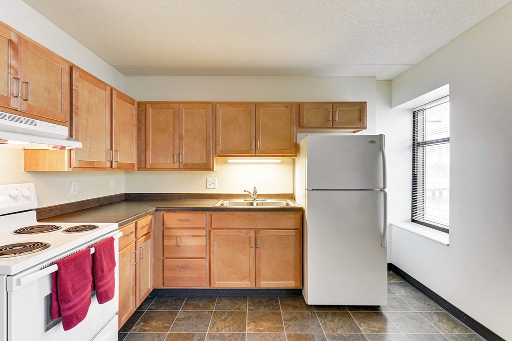 a kitchen with wooden cabinets and a white refrigerator