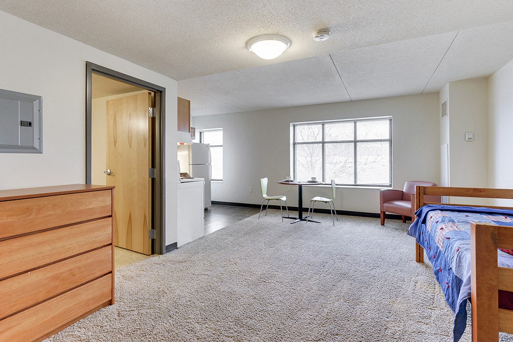 a bedroom with a bed and a desk in a room