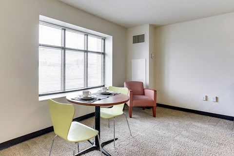 a dining room with a table and chairs and a large window